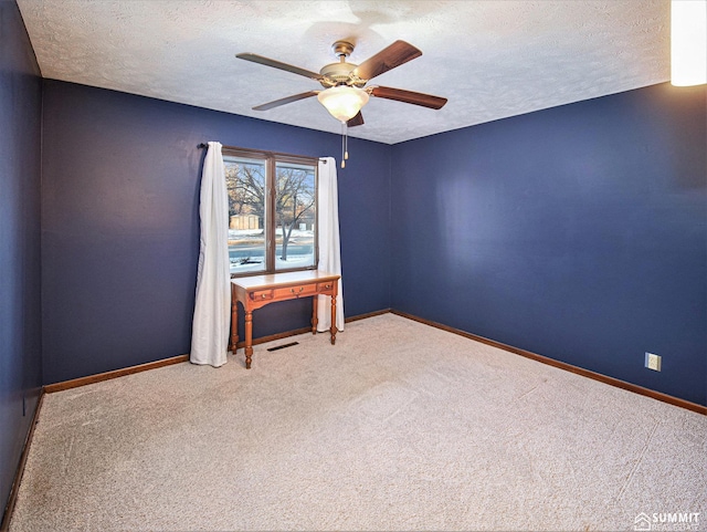 empty room featuring visible vents, a textured ceiling, and baseboards