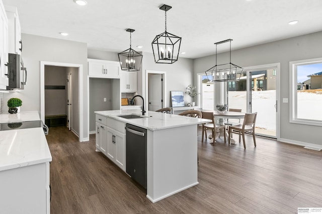 kitchen featuring a sink, white cabinets, appliances with stainless steel finishes, an island with sink, and decorative light fixtures