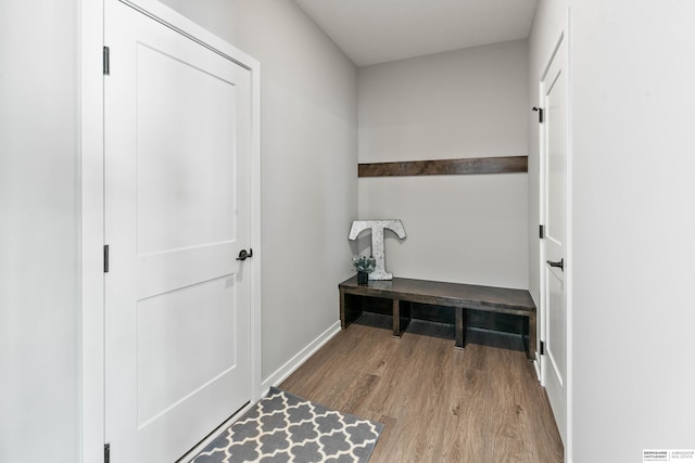 mudroom featuring light wood finished floors and baseboards