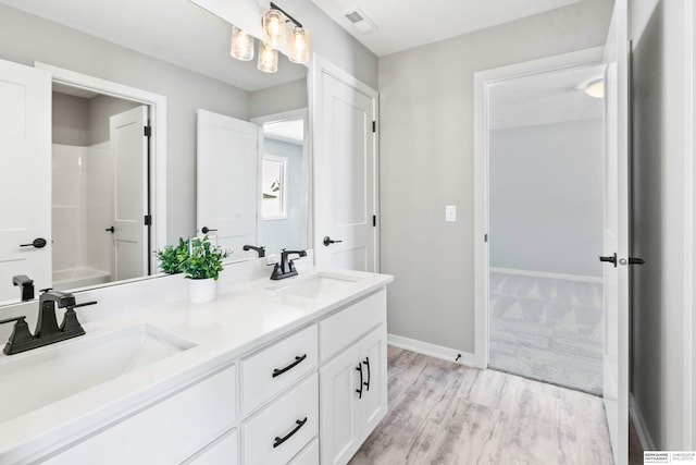 full bathroom featuring double vanity, baseboards, visible vents, and a sink