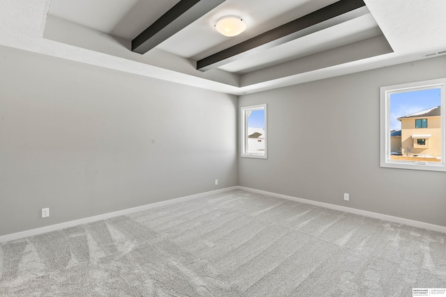 unfurnished room with carpet, visible vents, beamed ceiling, and baseboards