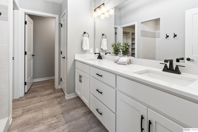 full bath featuring double vanity, a closet, baseboards, and a sink