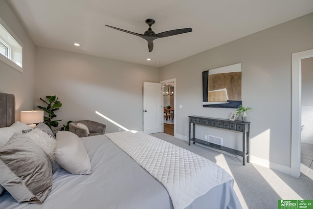 bedroom featuring light carpet, visible vents, baseboards, and ceiling fan with notable chandelier