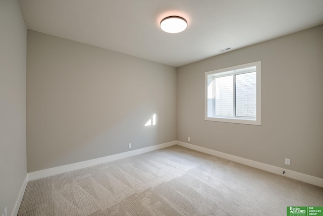 empty room featuring visible vents, light carpet, and baseboards