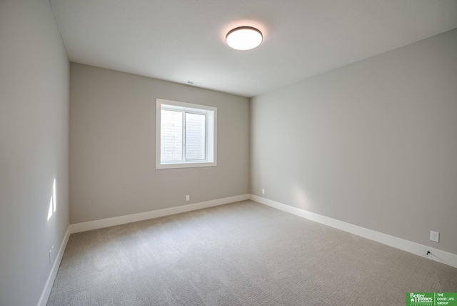 empty room with baseboards and light colored carpet