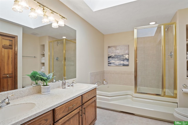 bathroom with a stall shower, a garden tub, a sink, and a skylight