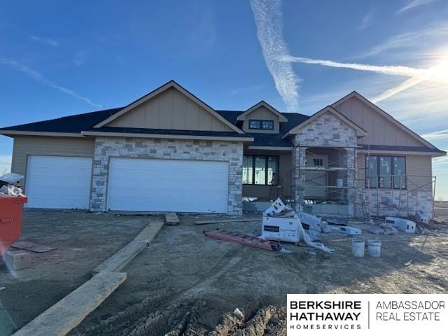 view of front of home with stone siding, board and batten siding, and an attached garage