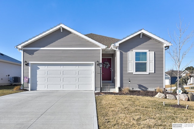 ranch-style home with an attached garage, central AC unit, a front lawn, and concrete driveway