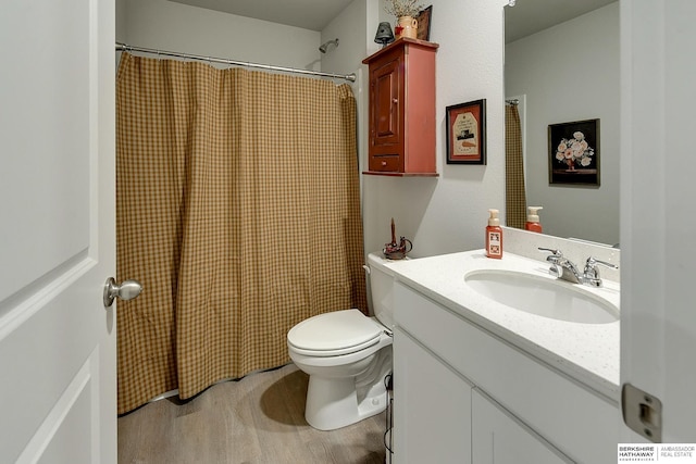 bathroom featuring vanity, a shower with shower curtain, wood finished floors, and toilet