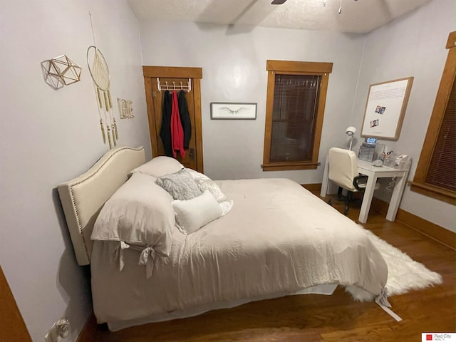 bedroom with ceiling fan, a closet, baseboards, and wood finished floors