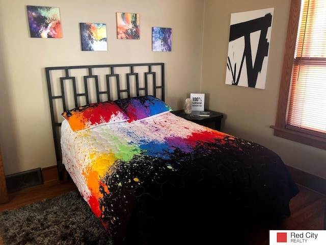 bedroom with dark wood-style floors