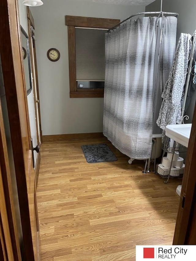 bathroom featuring wood finished floors and baseboards