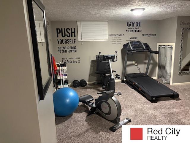 exercise area featuring baseboards and a textured ceiling