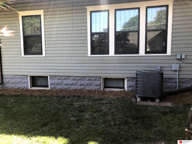 view of side of property featuring a yard and cooling unit