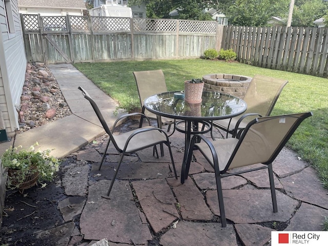 view of patio with an outdoor fire pit, fence, and outdoor dining space