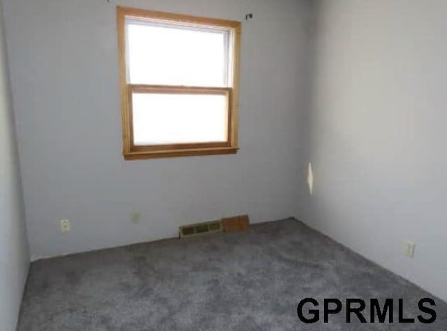 carpeted spare room featuring visible vents