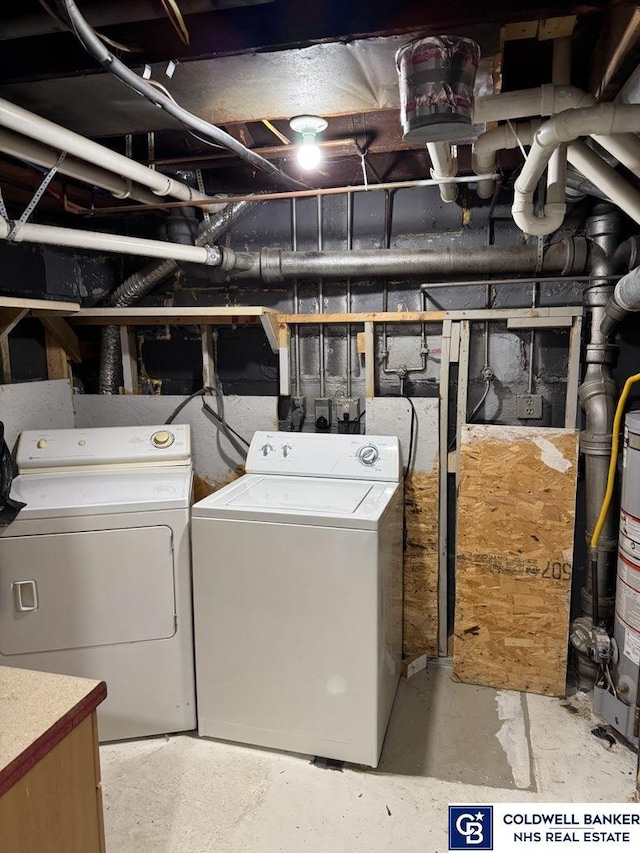 washroom featuring washing machine and dryer, laundry area, and water heater