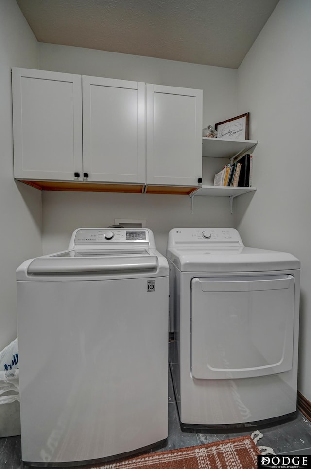 clothes washing area featuring cabinet space and independent washer and dryer