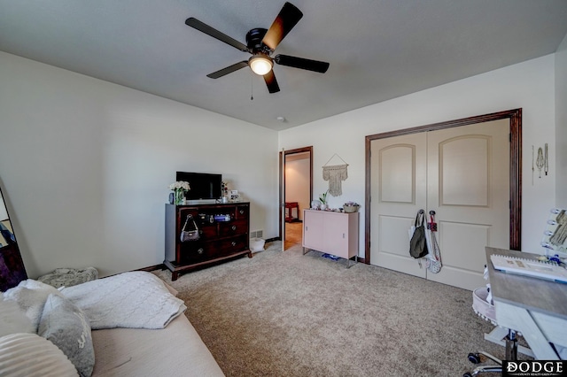 bedroom featuring a closet, light colored carpet, and ceiling fan