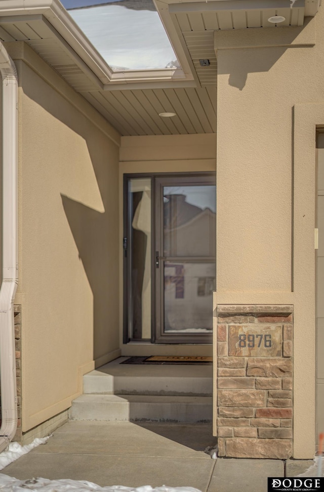 view of exterior entry with stucco siding