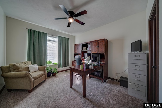 home office with a textured ceiling, baseboards, a ceiling fan, and light colored carpet