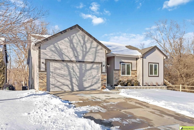 single story home with an attached garage, stone siding, and driveway