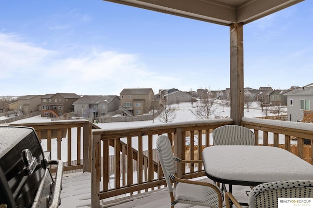 snow covered deck featuring a residential view