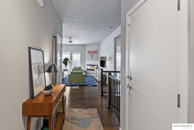 hallway with dark wood-type flooring and a textured ceiling