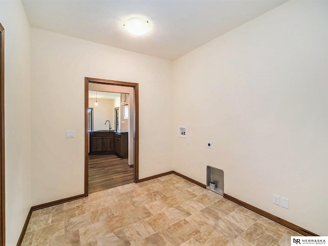 laundry room with laundry area, baseboards, hookup for an electric dryer, washer hookup, and a sink