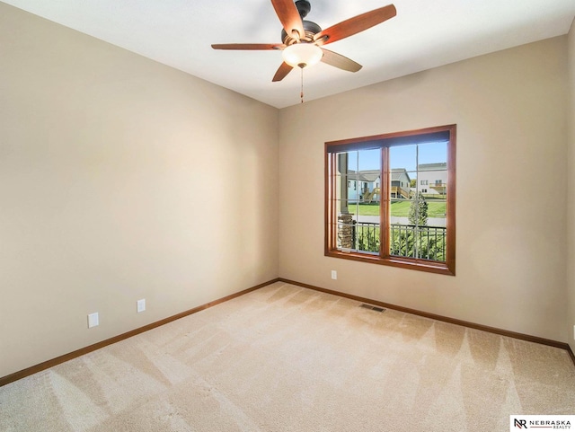 spare room with visible vents, baseboards, a ceiling fan, and light colored carpet