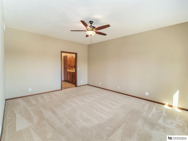 spare room with light carpet, ceiling fan, and baseboards