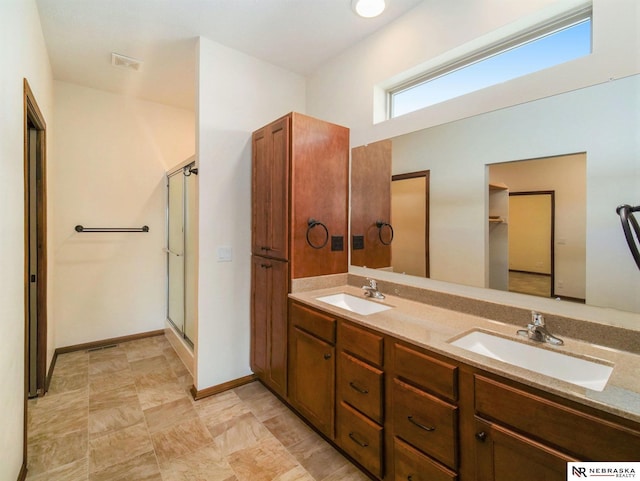 bathroom featuring double vanity, a stall shower, a sink, and visible vents