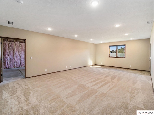 spare room with visible vents, light carpet, and baseboards