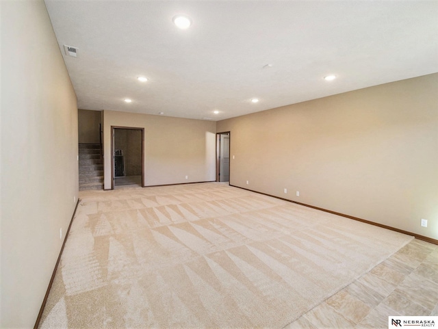 empty room featuring stairs, visible vents, light colored carpet, and recessed lighting