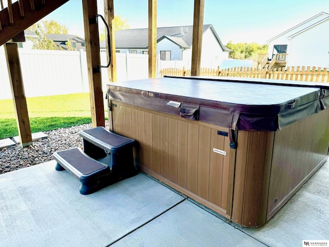 view of patio featuring a residential view, fence, and a hot tub