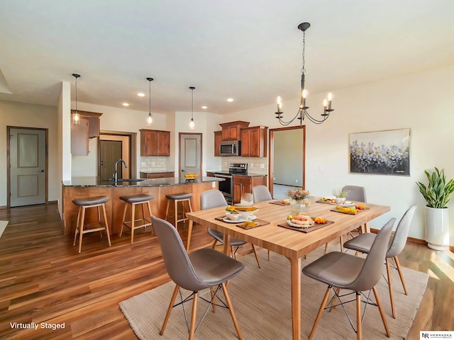 dining room featuring a notable chandelier, dark wood-style flooring, and recessed lighting