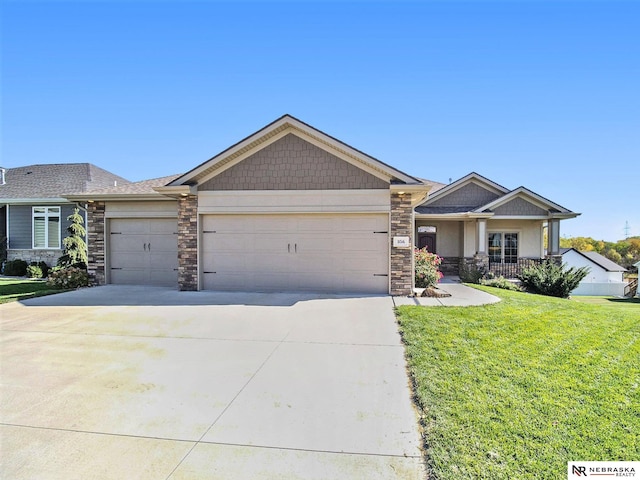 craftsman-style house featuring a porch, a garage, concrete driveway, stone siding, and a front yard