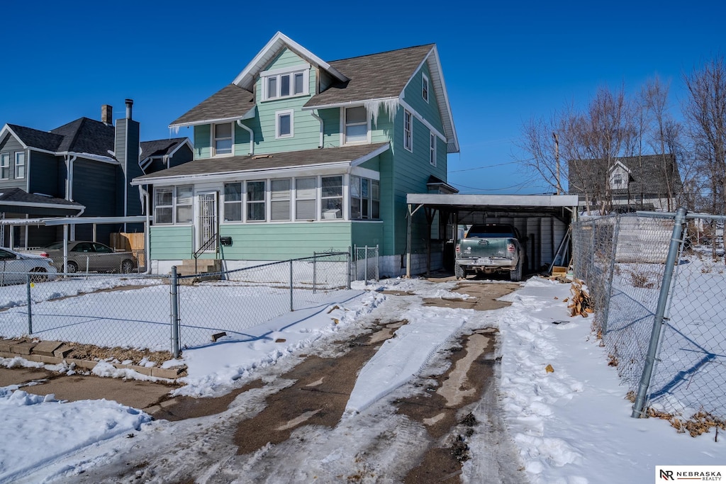 american foursquare style home with driveway and fence