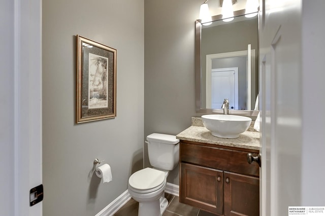 bathroom featuring vanity, toilet, and baseboards