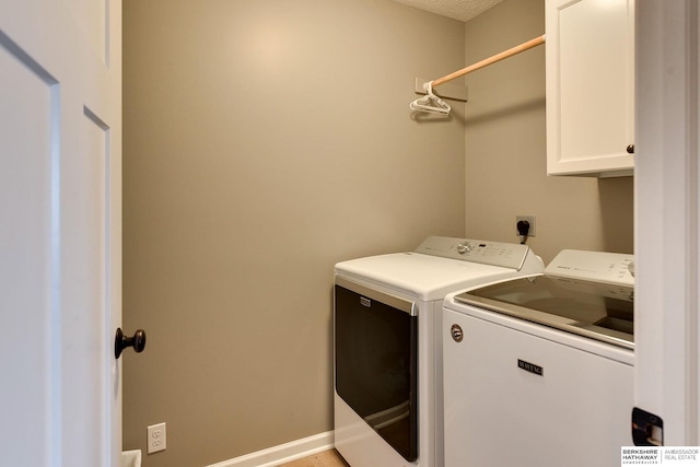 washroom featuring cabinet space and washer and clothes dryer