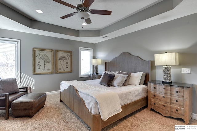 bedroom featuring light colored carpet, visible vents, ceiling fan, a textured ceiling, and baseboards