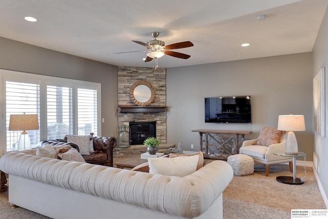 carpeted living area featuring visible vents, baseboards, a ceiling fan, a stone fireplace, and recessed lighting