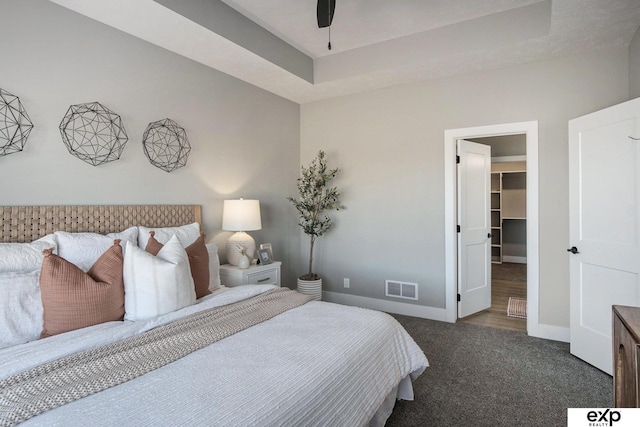 carpeted bedroom featuring ceiling fan, visible vents, baseboards, a spacious closet, and a closet