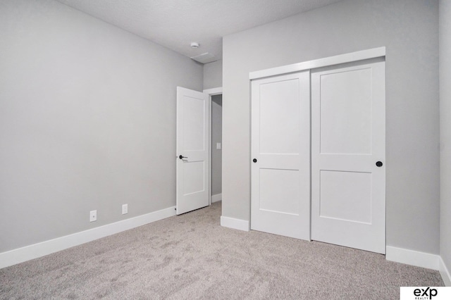 unfurnished bedroom featuring a closet, carpet, and baseboards