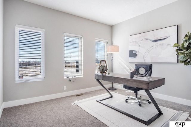 carpeted office space featuring visible vents and baseboards