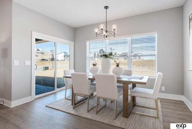 dining area featuring baseboards, a chandelier, and wood finished floors