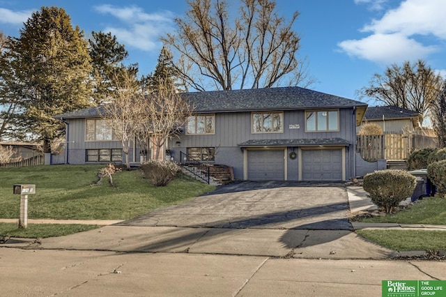 view of front of home featuring a garage, driveway, a front yard, and fence