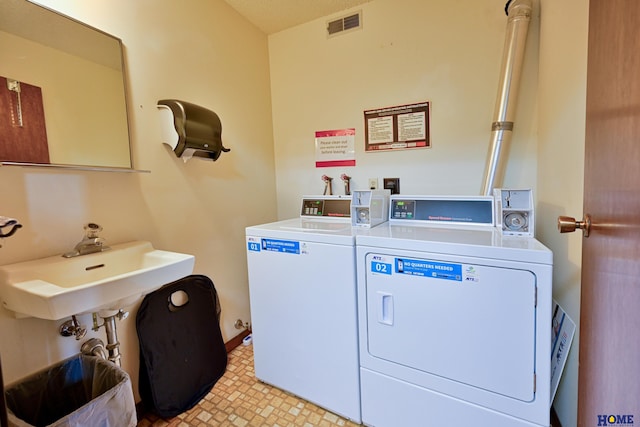 community laundry room with washing machine and clothes dryer and visible vents