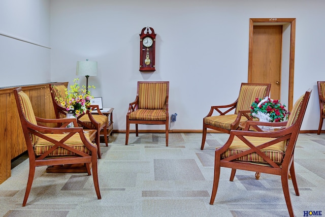 living area featuring light carpet and baseboards