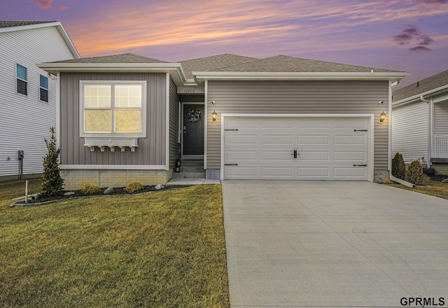 view of front facade featuring a garage, concrete driveway, a front lawn, and a shingled roof